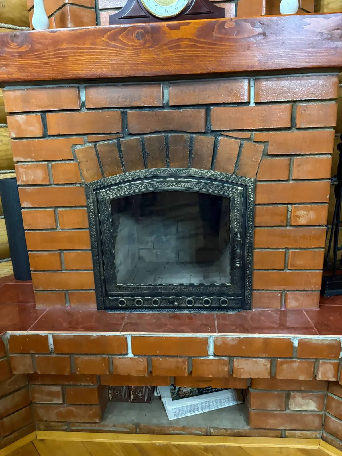 Каминная дверца с патиной в камине из красного кирпича